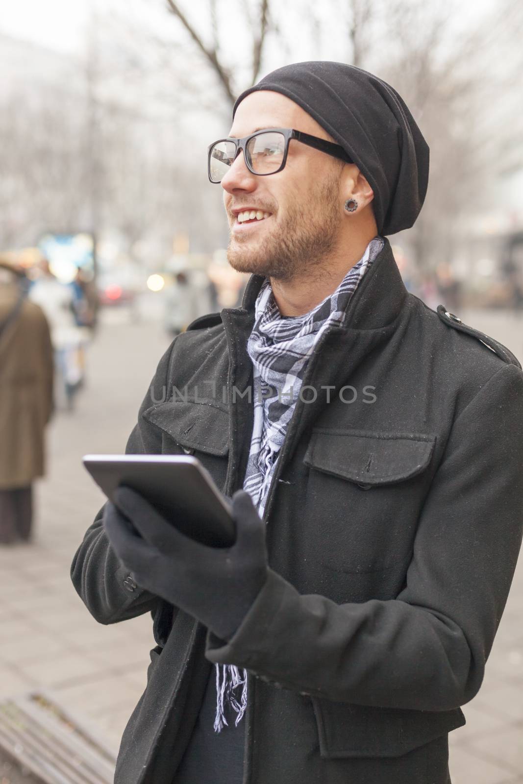 Young man reading messages and information using an i-pad tablet computer.