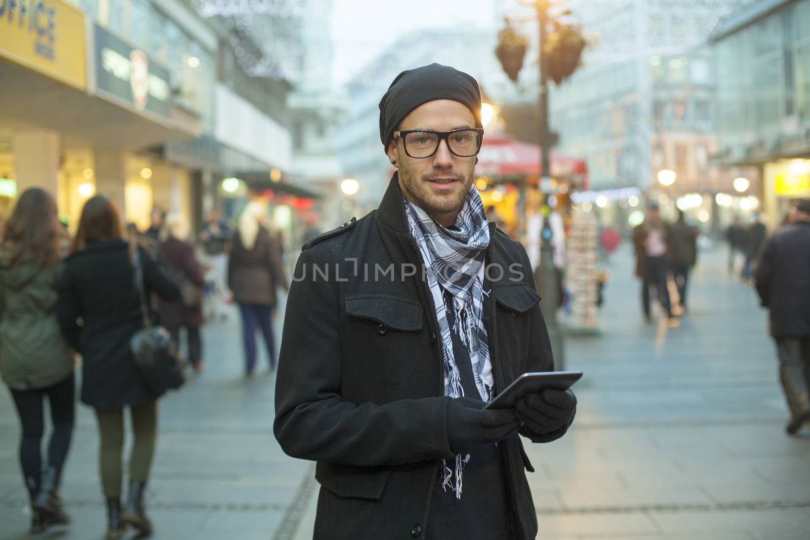 Urban man holdin tablet computer on street by adamr