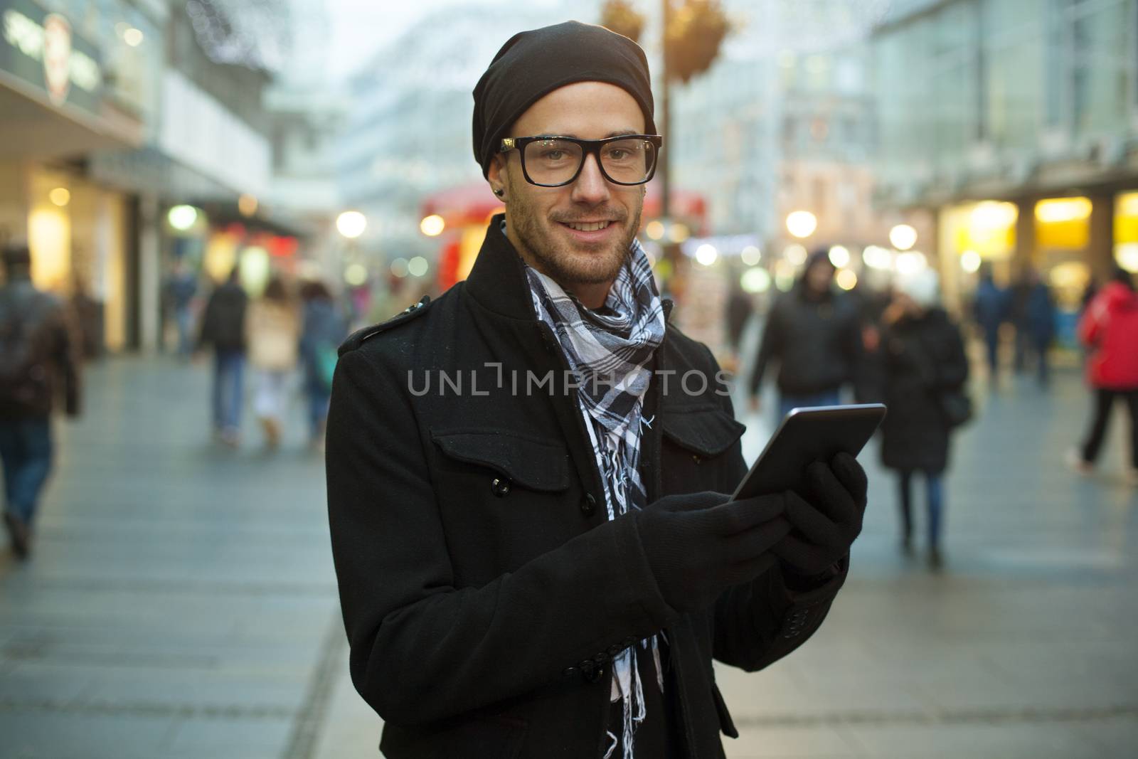 Urban man holdin tablet computer on street by adamr