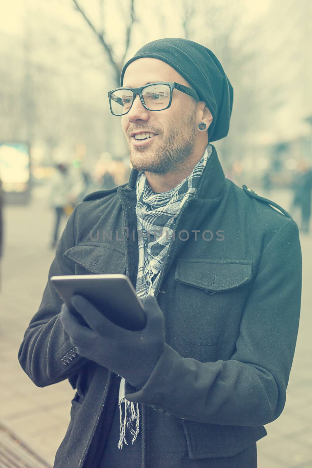 Young man reading messages and information using an i-pad tablet computer.