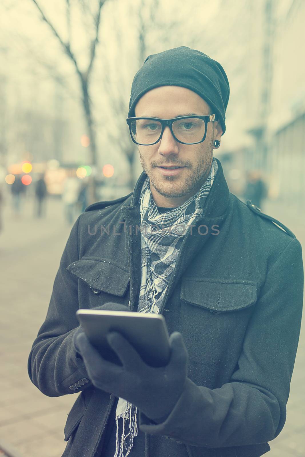 Young man reading messages and information using an i-pad tablet computer.