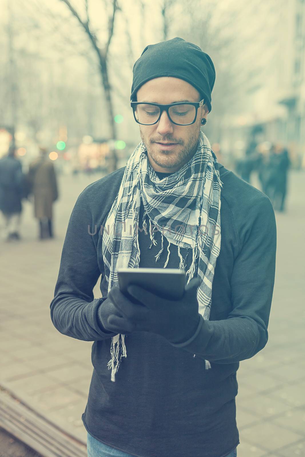 Young man reading messages and information using an i-pad tablet computer.