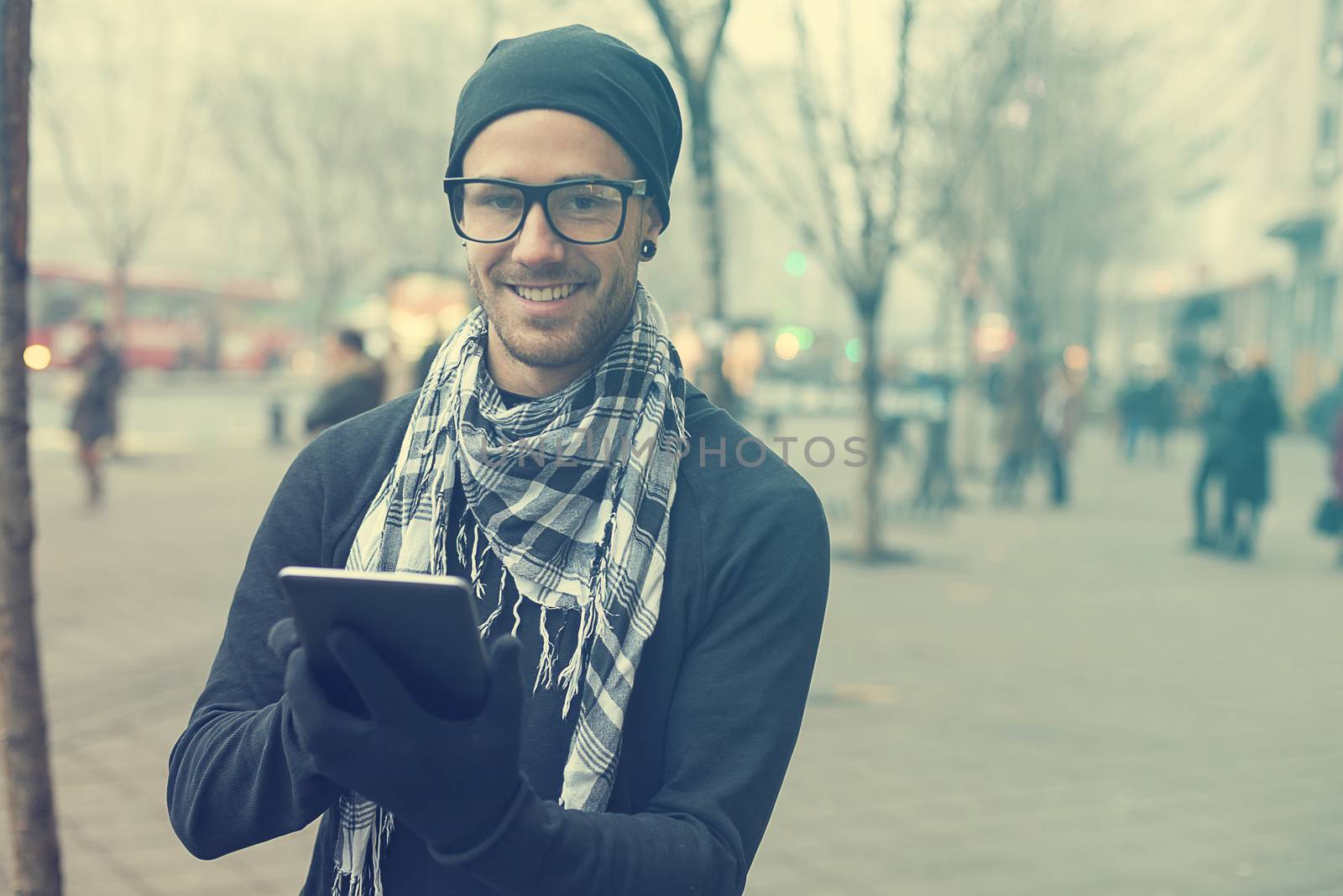 Man holdin i-pad tablet computer on street by adamr