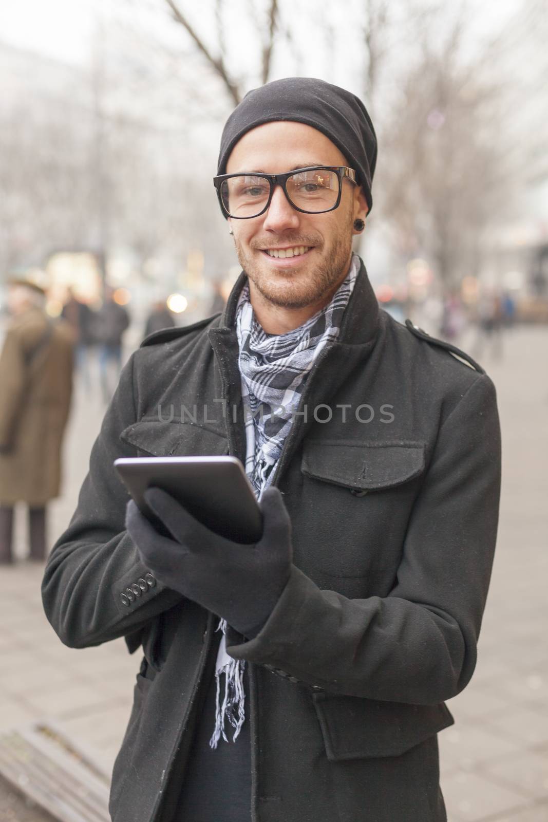 Young man reading messages and information using an i-pad tablet computer.