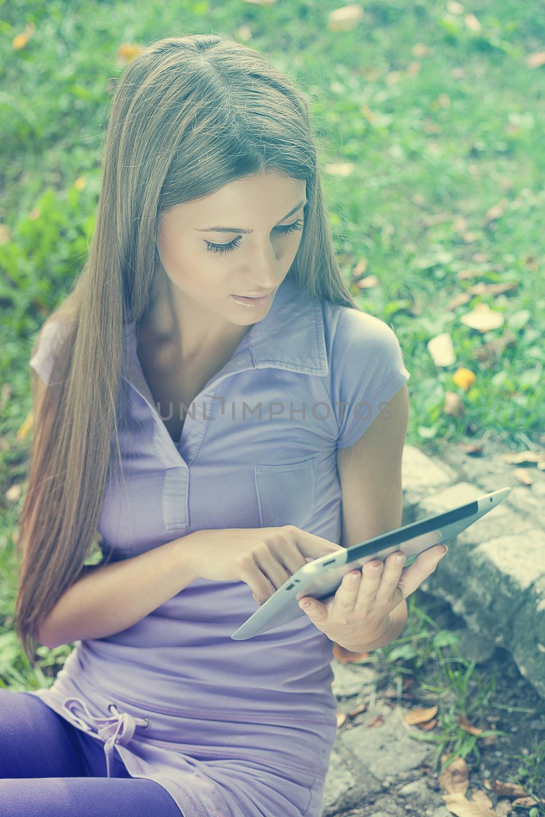 Beautiful Young Woman With Tablet Computer In Park