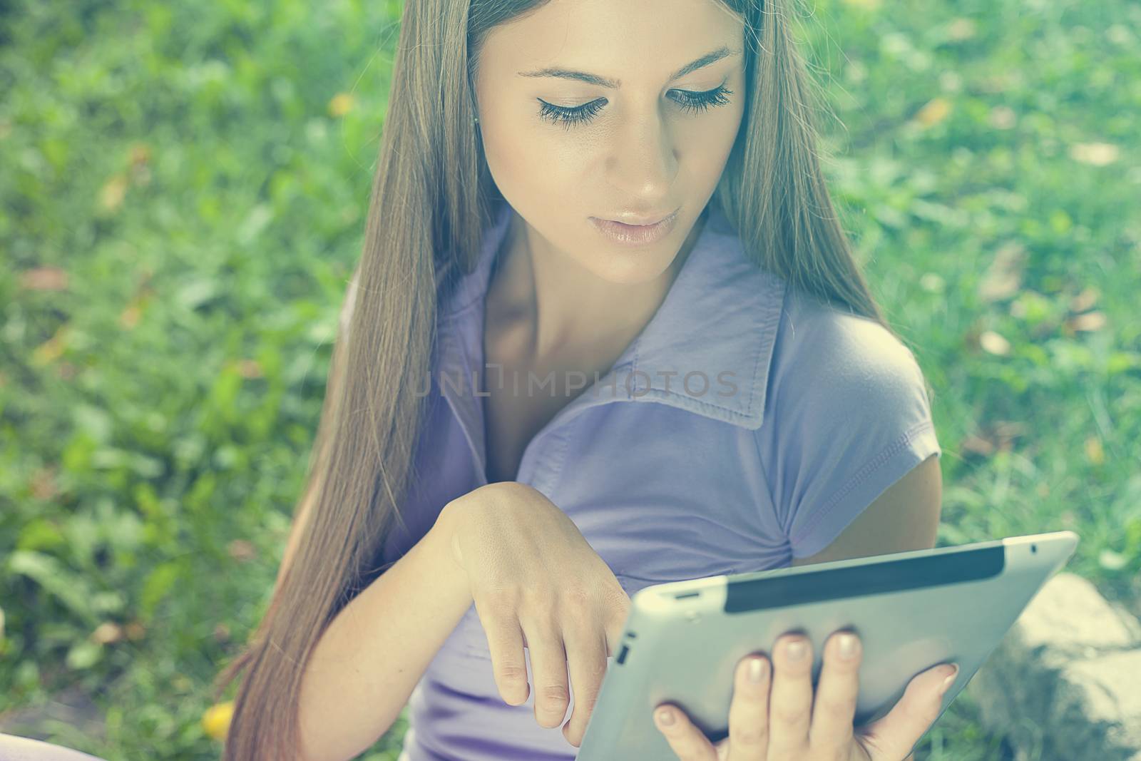 Beautiful Young Woman With Tablet Computer In Park