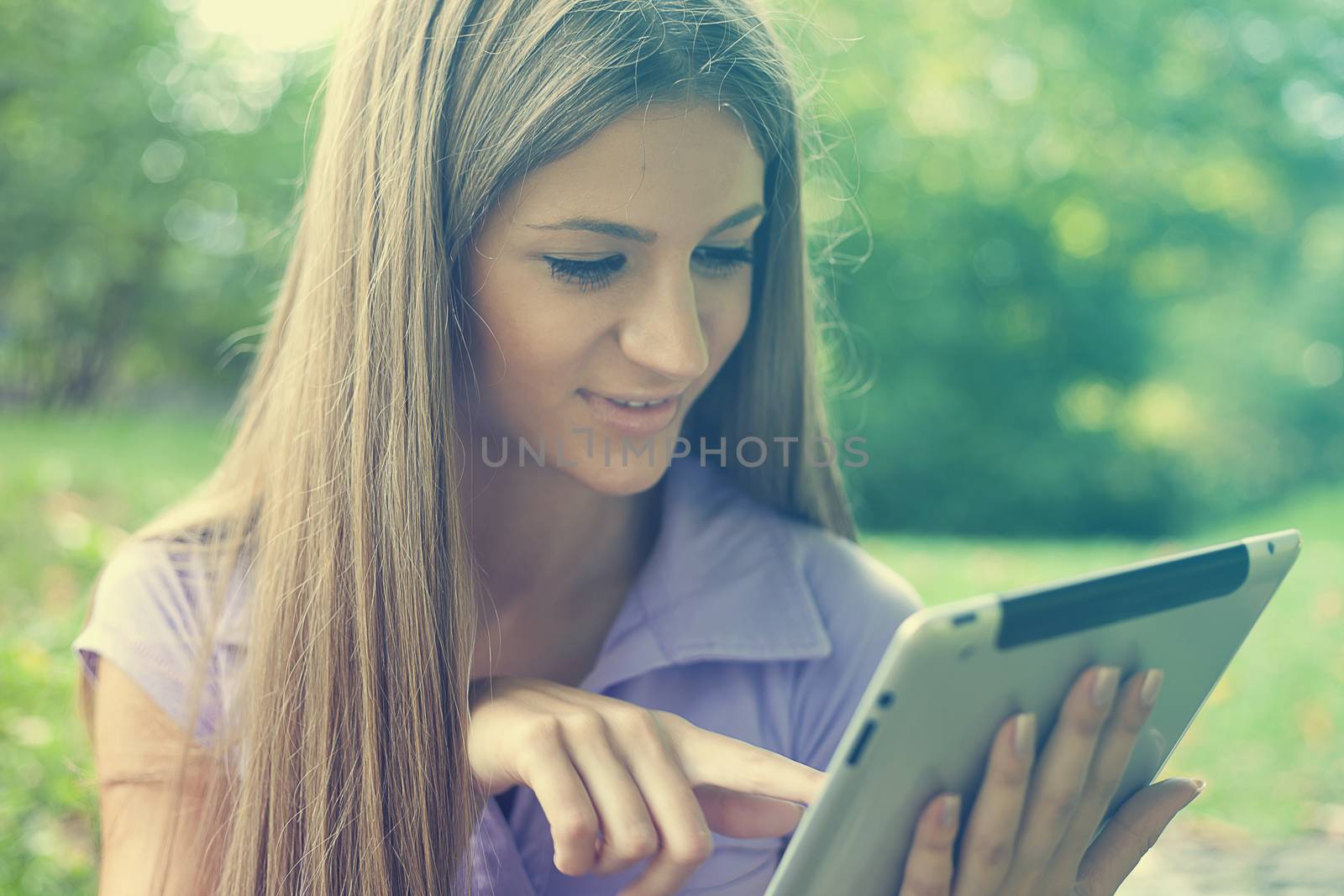 Beautiful Young Woman With Tablet Computer In Park