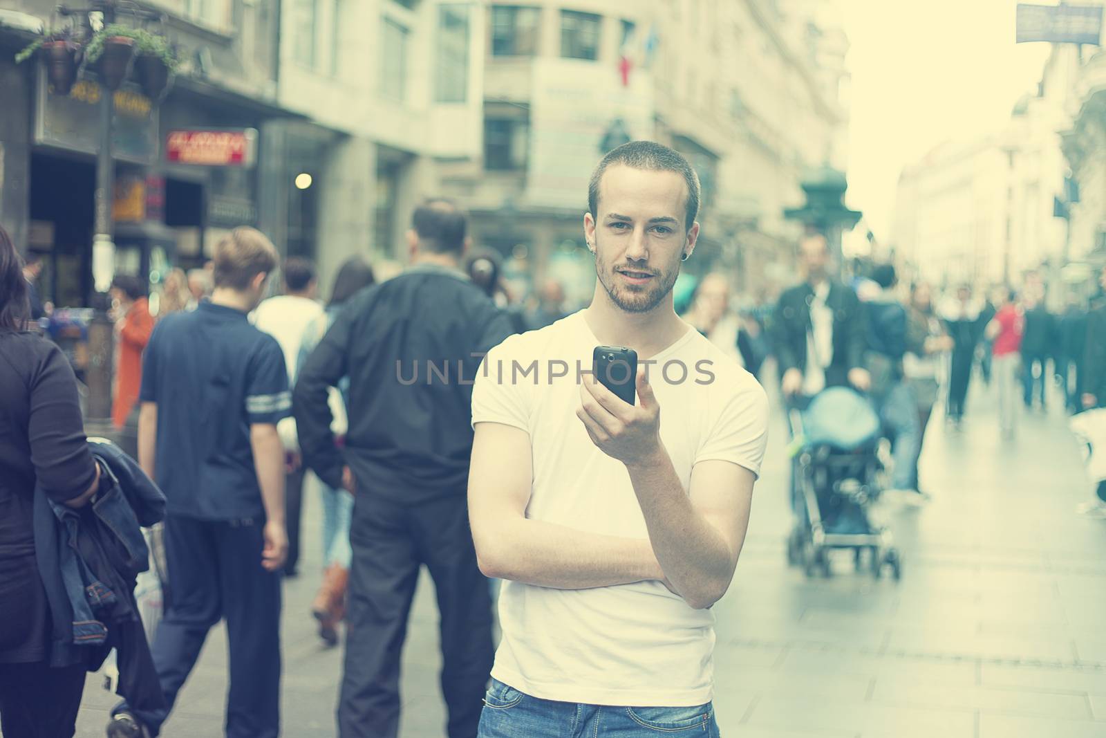 Young Man in City with mobile phone by adamr