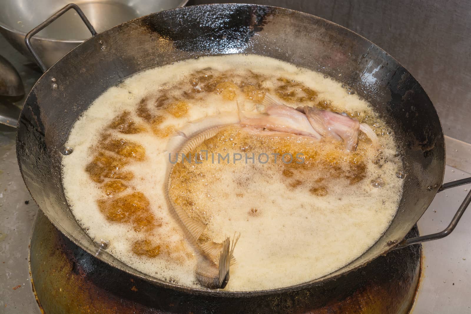 Fresh sheatfish being Fried in Hot Vegetable Oil in Iron Pan, Thai cuisine or Thai Food