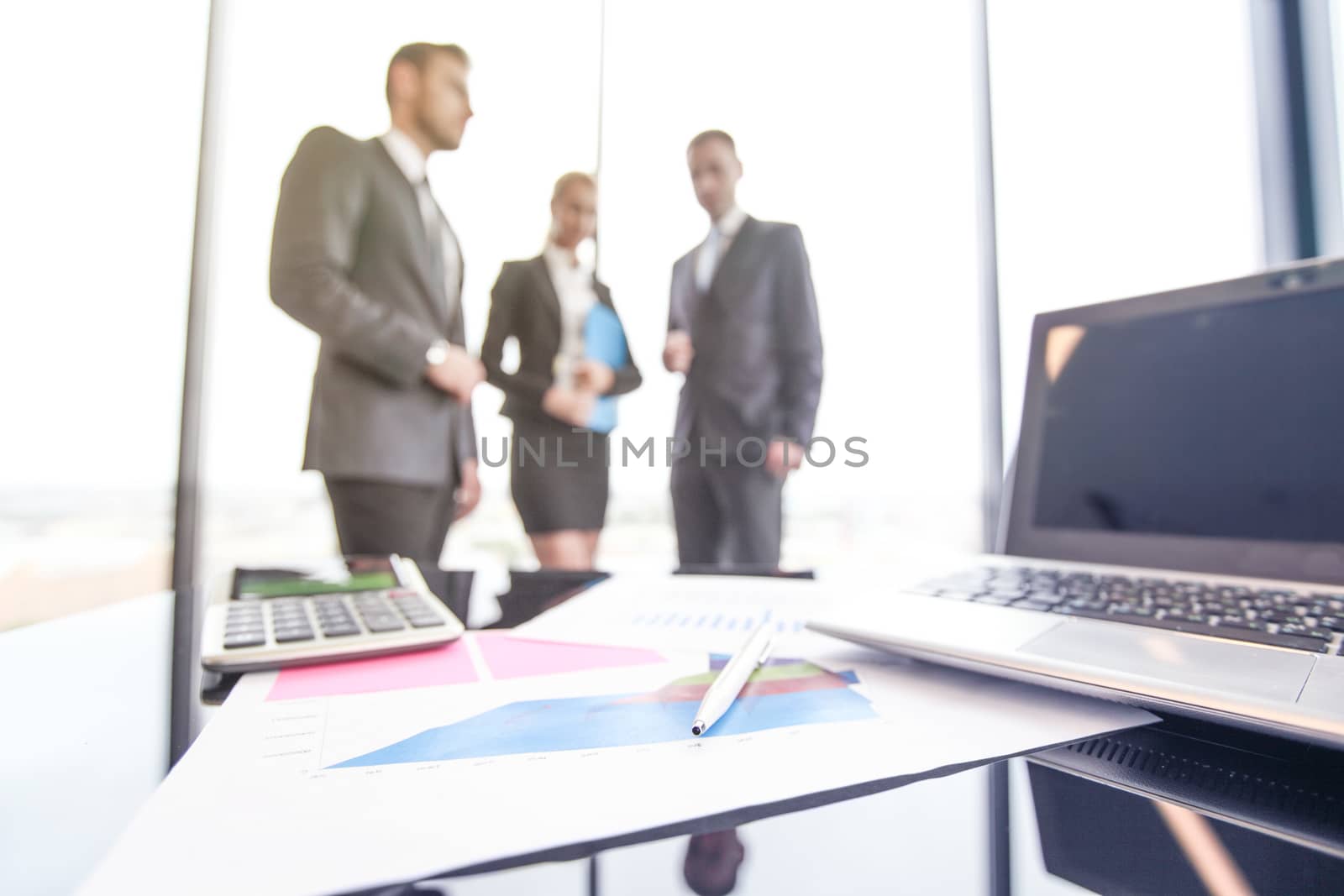 Mixed group of people in business meeting working with documents and computers