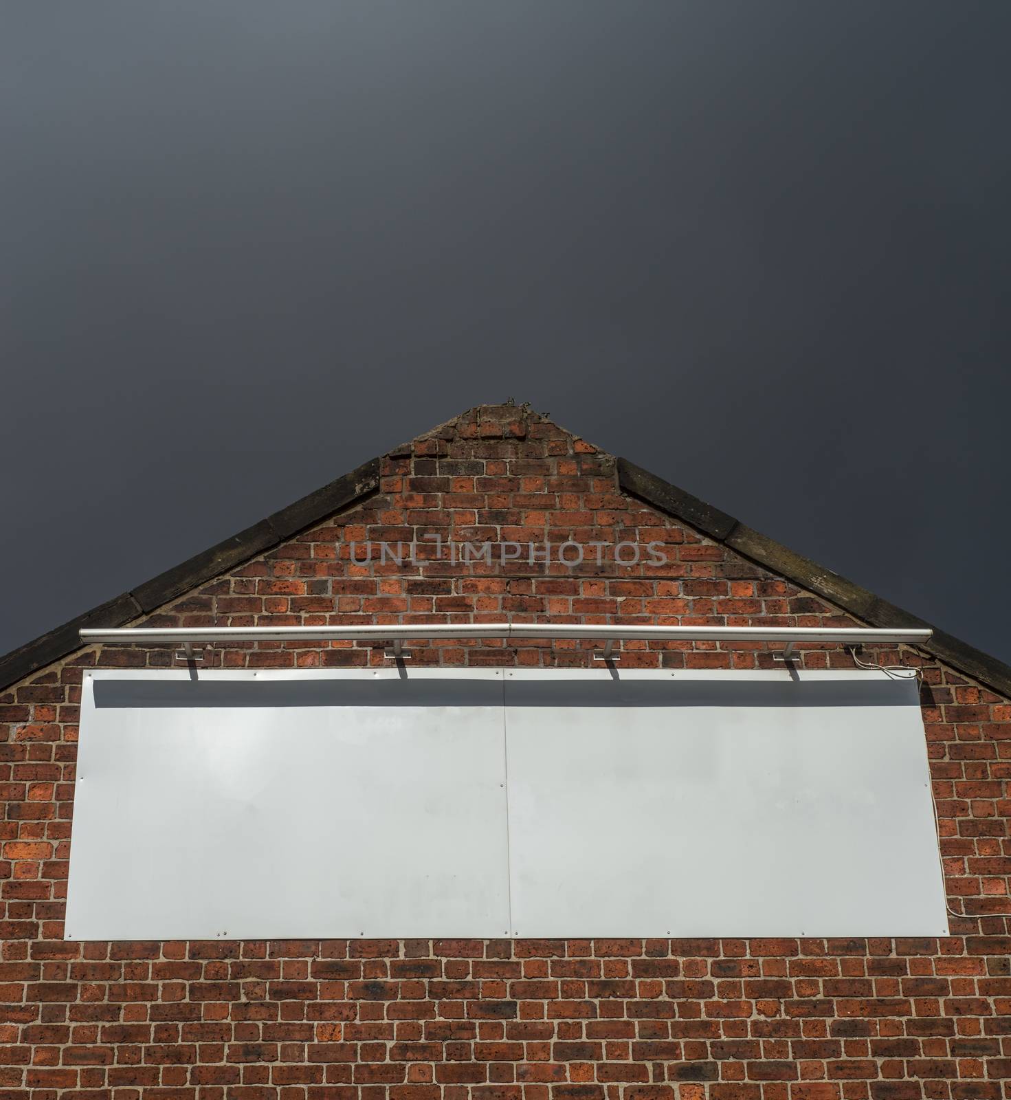 Blank Billboard Sign On An Old Red Brick Factory Building With Moody Sky