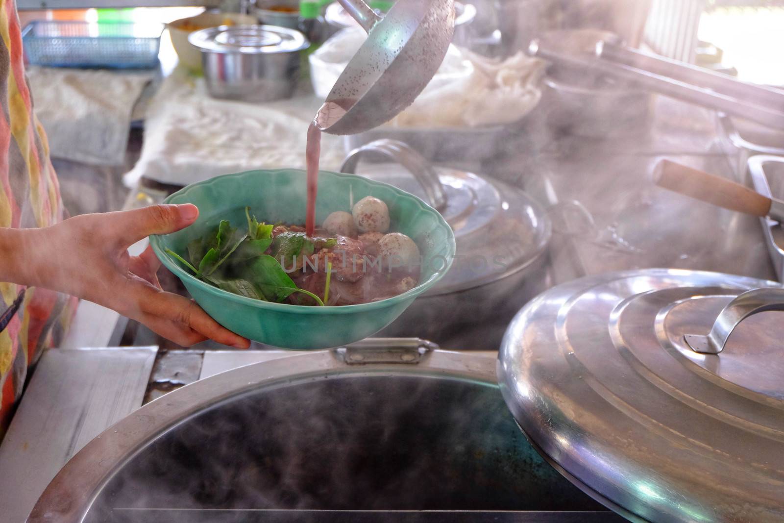 The ladle is drained in a bowl of noodles,Cooking noodle in thailand,the noodles pork and beef.