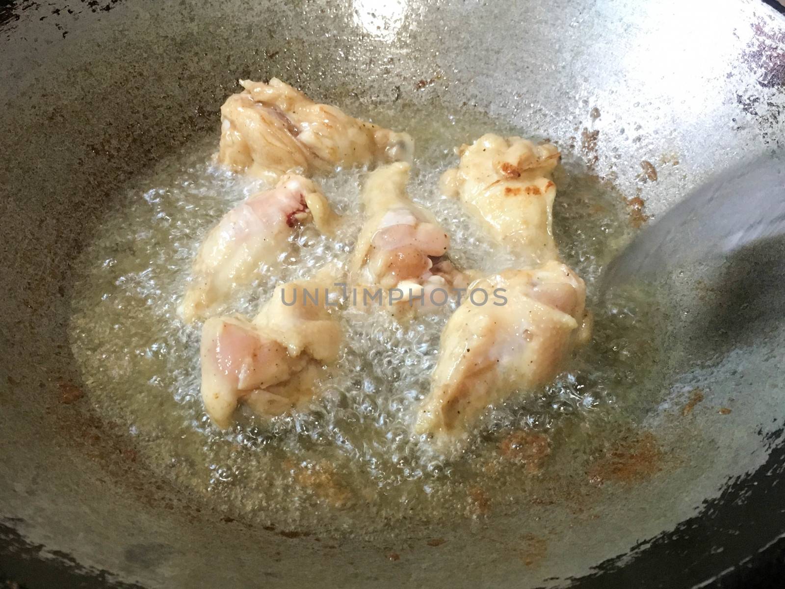 Legs of chicken gripping down are fried in hot oil. by e22xua