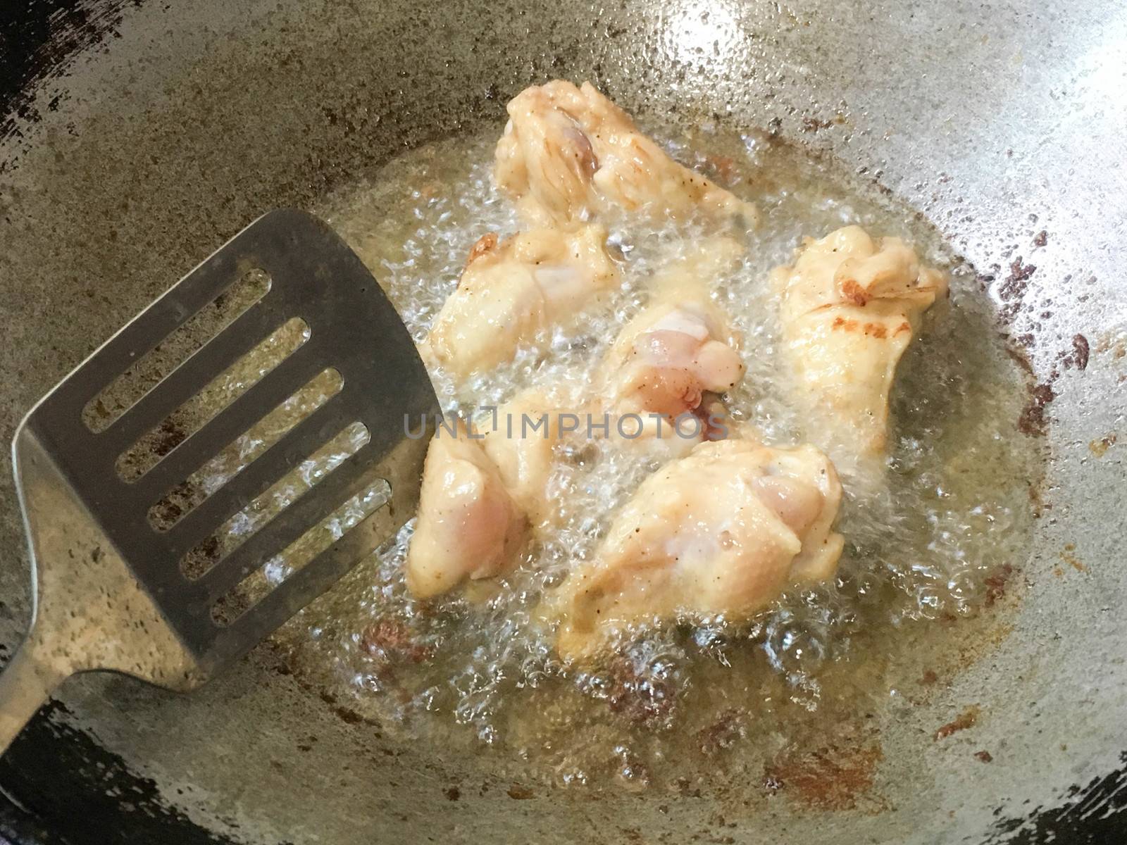 Legs of chicken gripping down are fried in hot oil.