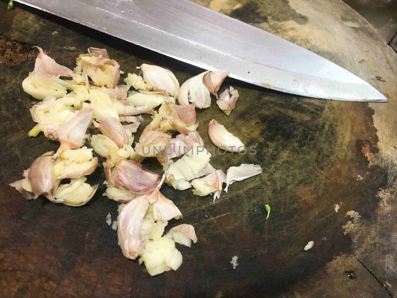 Garlic smashed and knife  isolated on wood background by e22xua