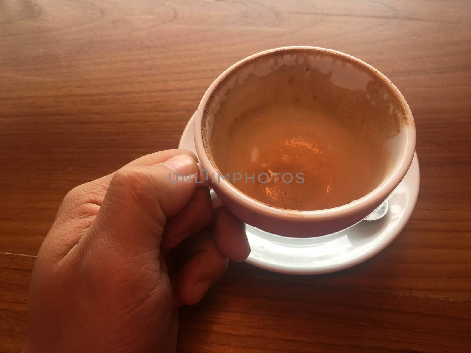 Male hands holding cups of coffee on wooden table background,No coffee