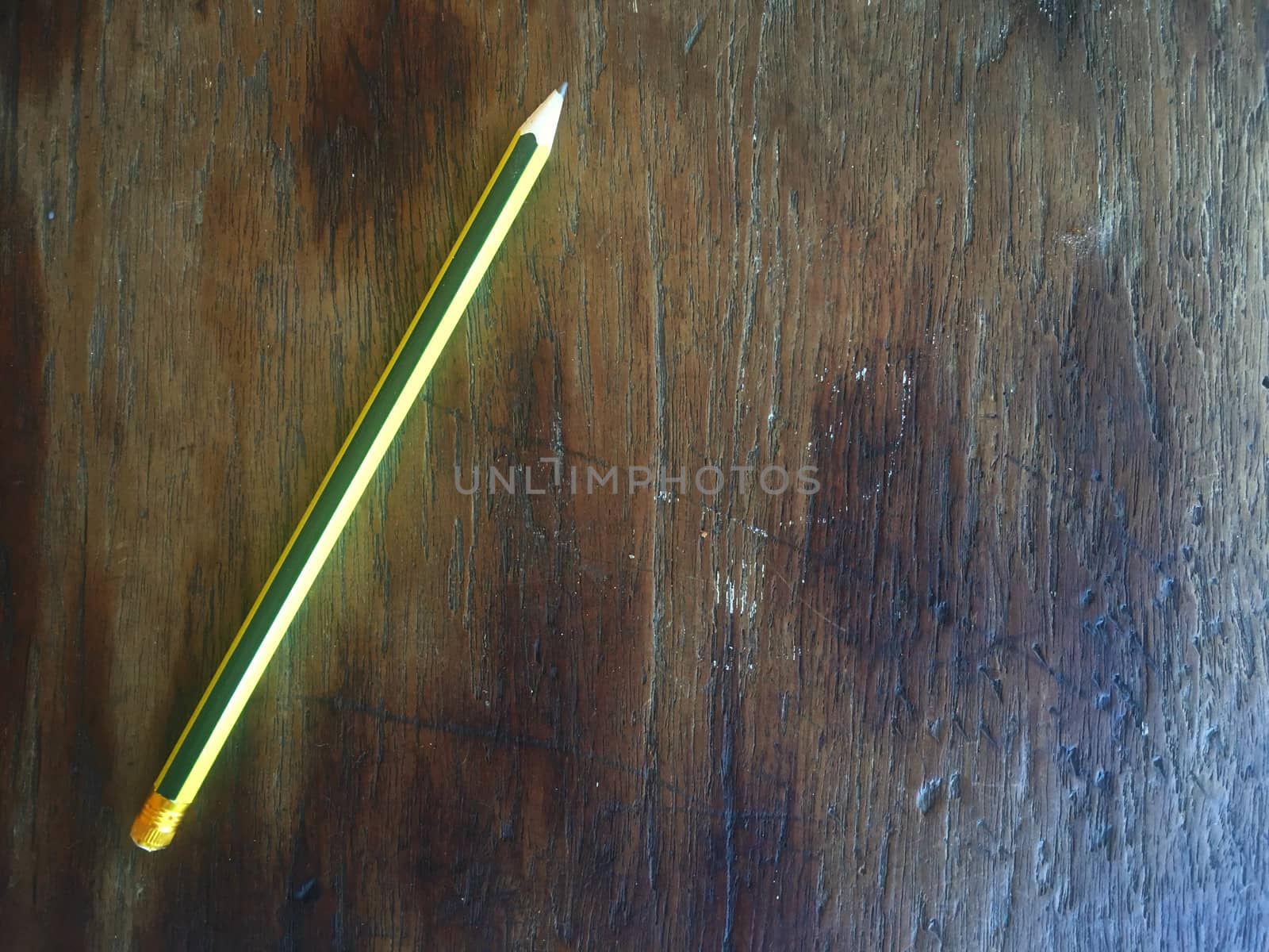 Green and yellow pencil on wood floor