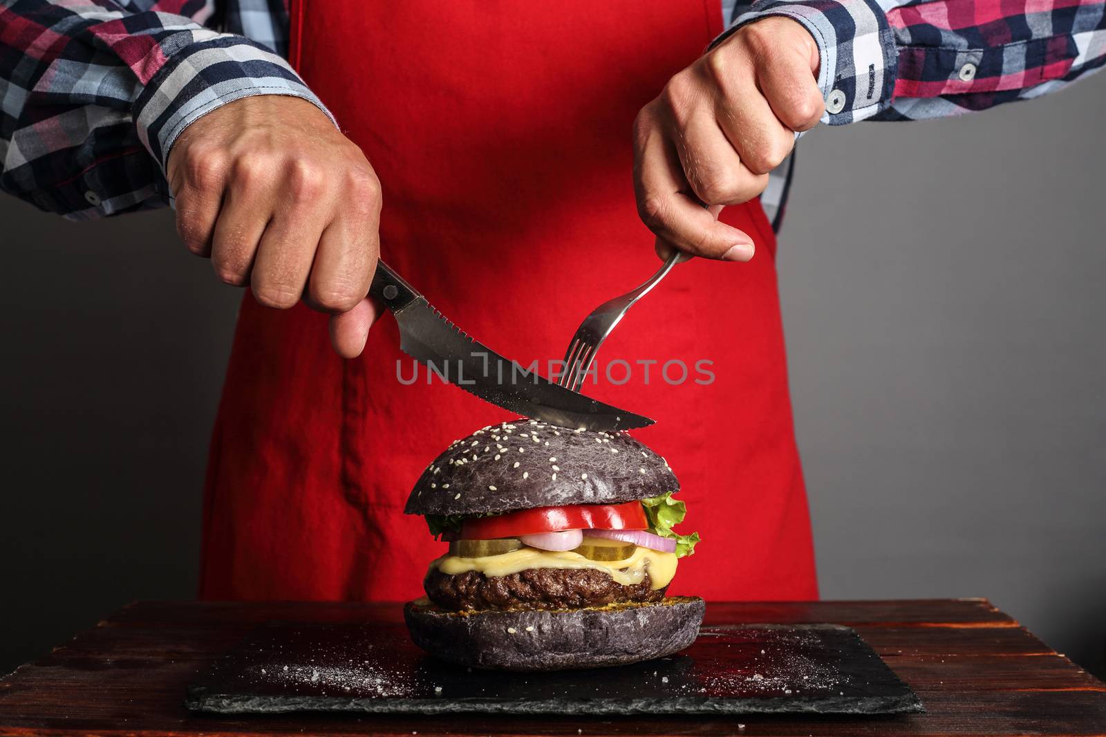 Man cuttung fresh self made burger close up