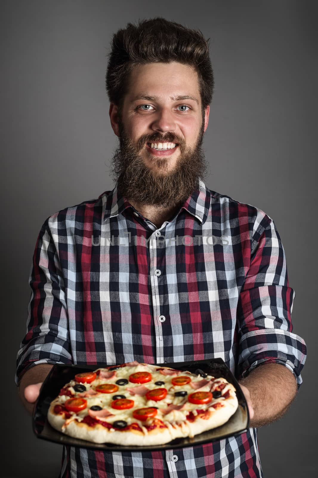 Happy smiling man holding home made pizza