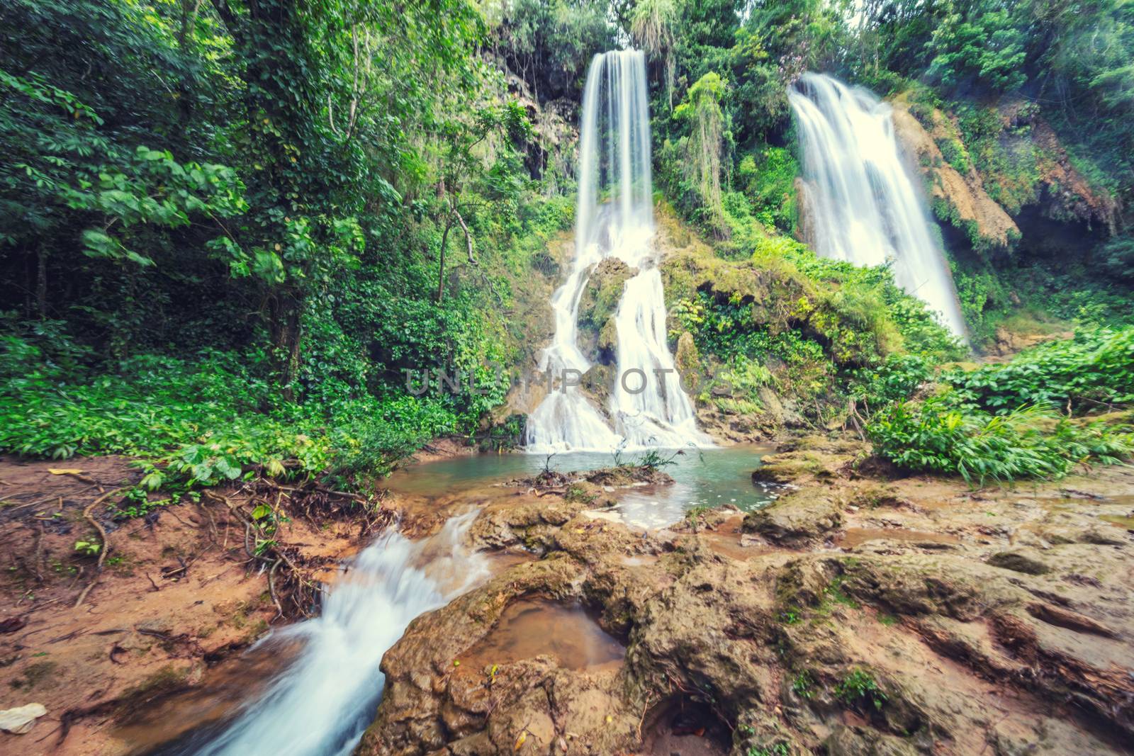 Waterfall in rainforest jungle flowing between the rocks El Rosio, river Melodioso, Guanayara park,Cuba 