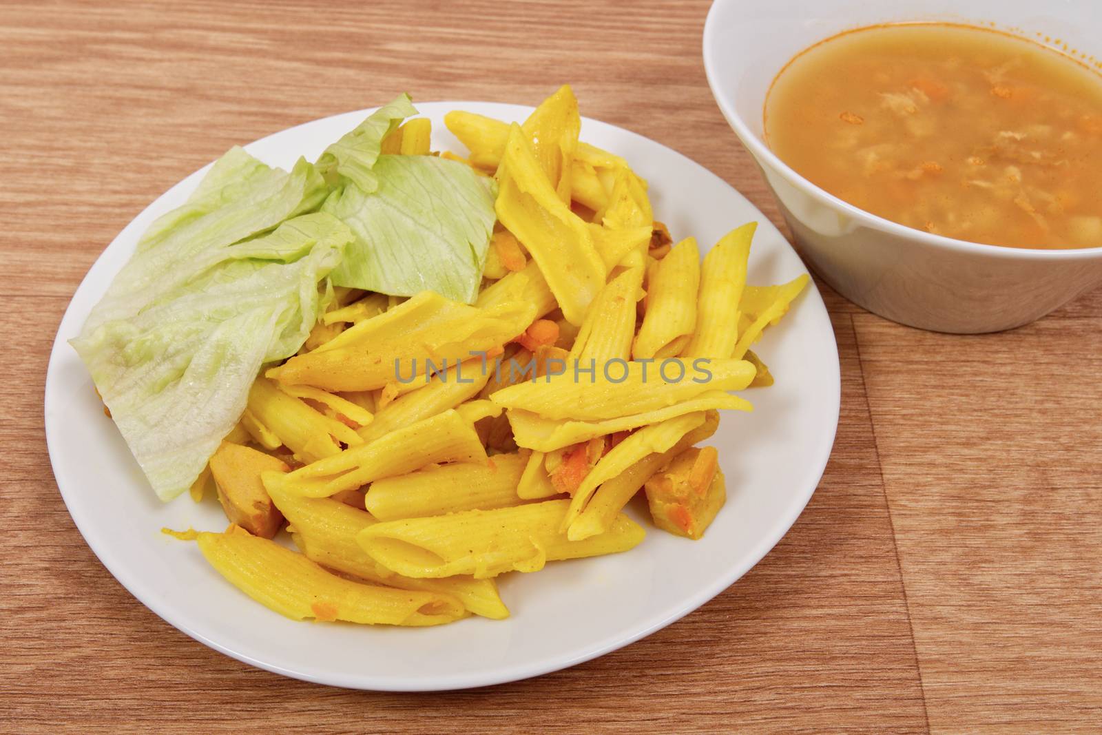 Baked pasta with curry on a wooden table