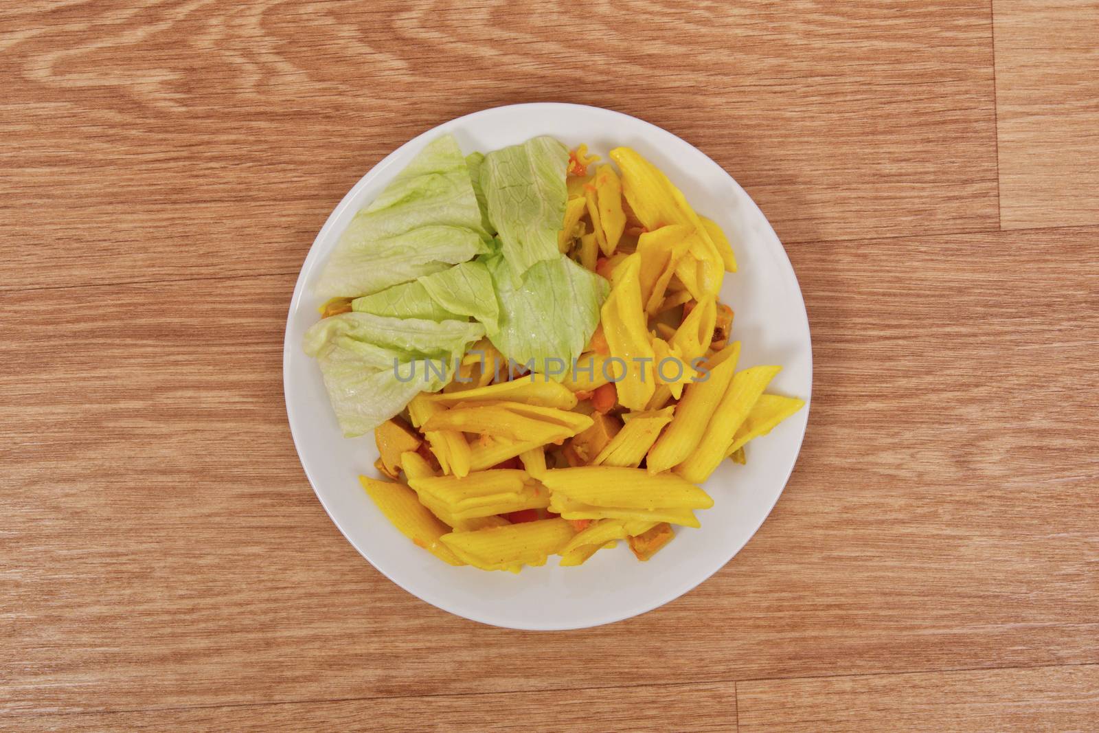 Baked pasta with curry on a wooden table