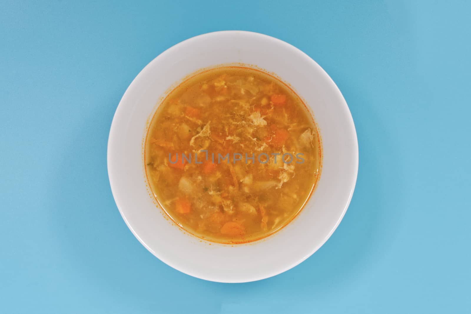 Groat soup with vegetables on a blue background