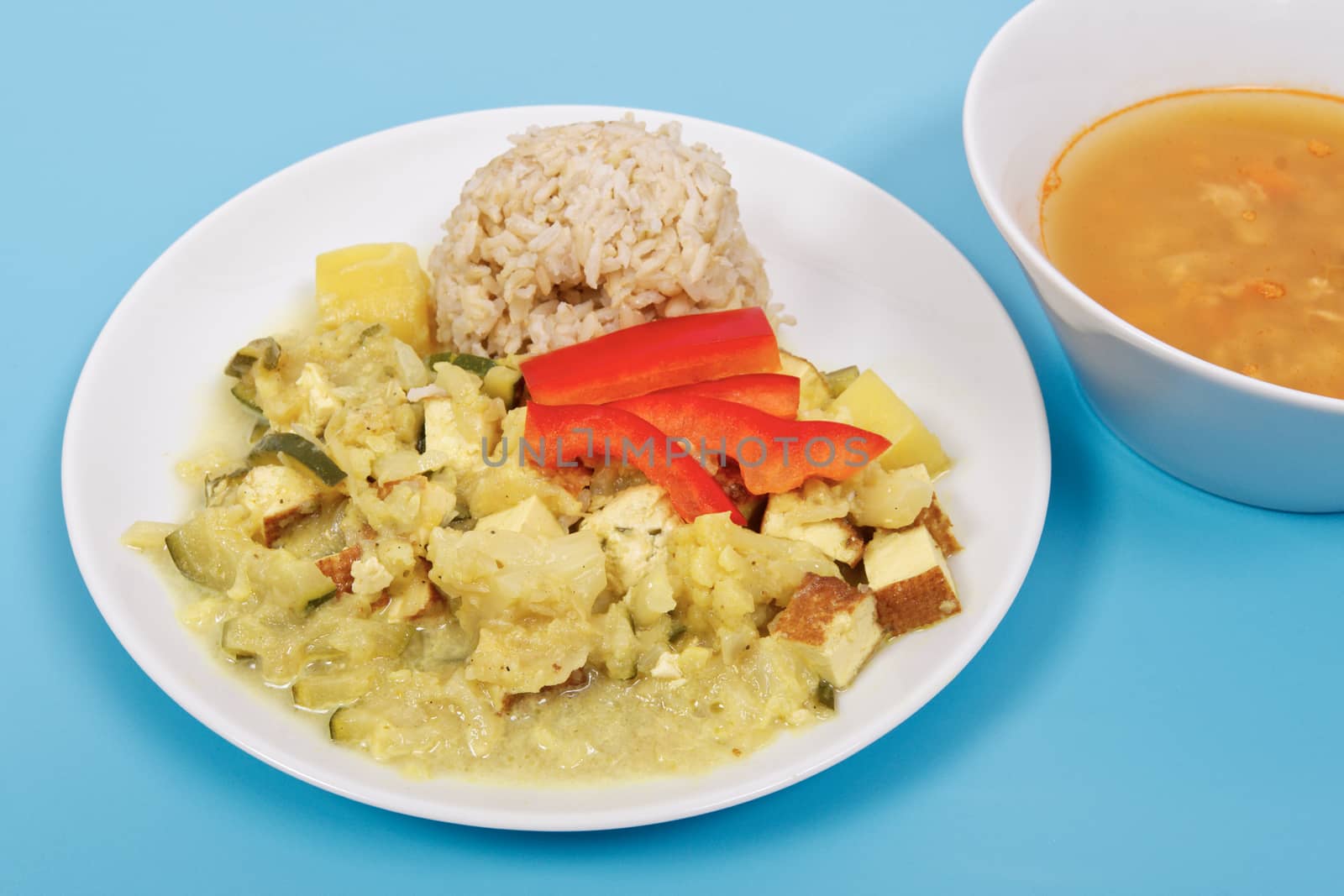 Cauliflower mixture with curry and rice on a blue background