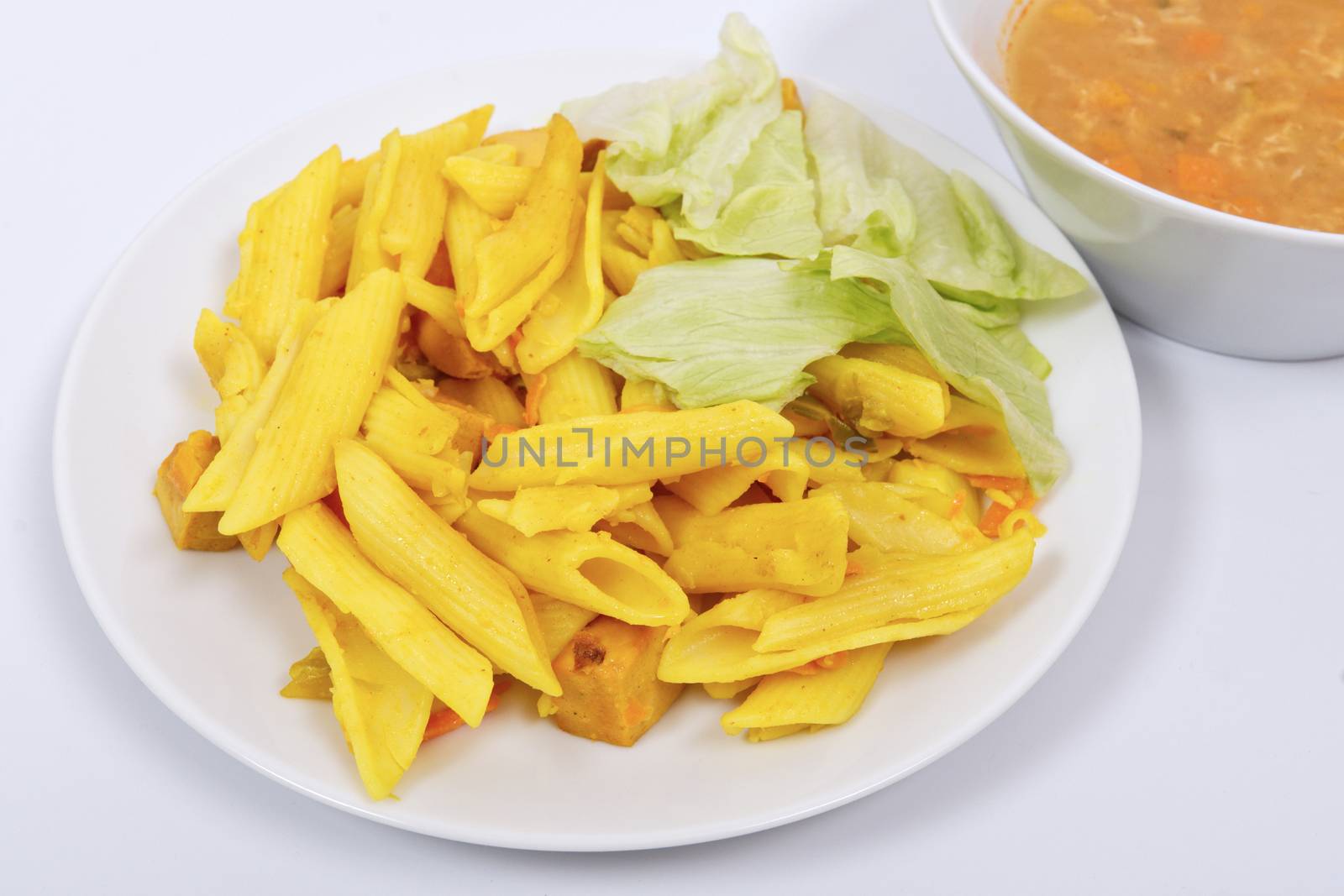 Baked pasta with curry on a white background