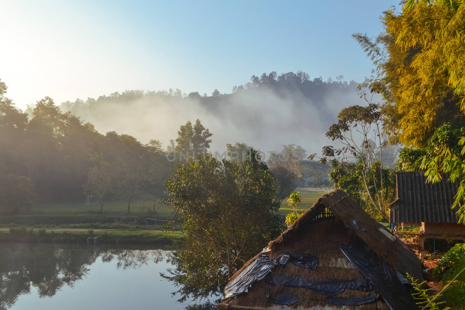 Cottage in the village among mountain and fog