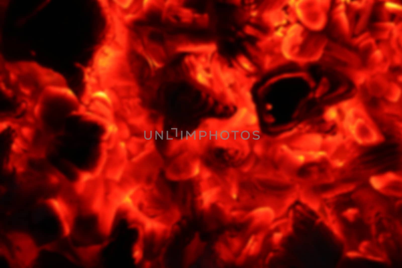Ash fire blurred in dark night. Campfire blurry coals burn in the darkness. Ejection nofocus lava