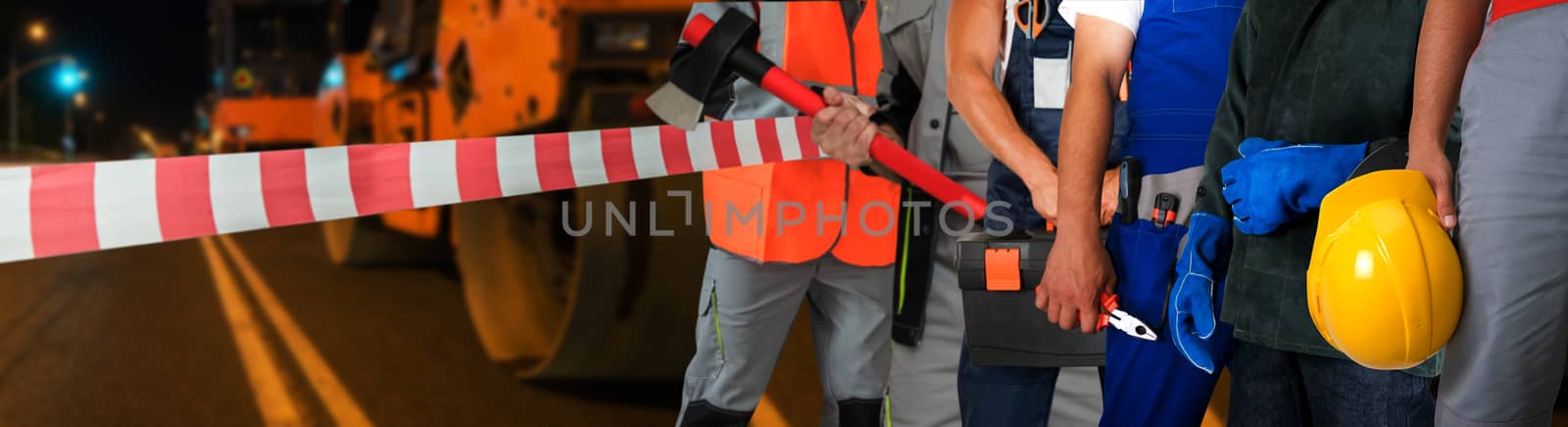 Workers on a road construction, repairing the road in the night city