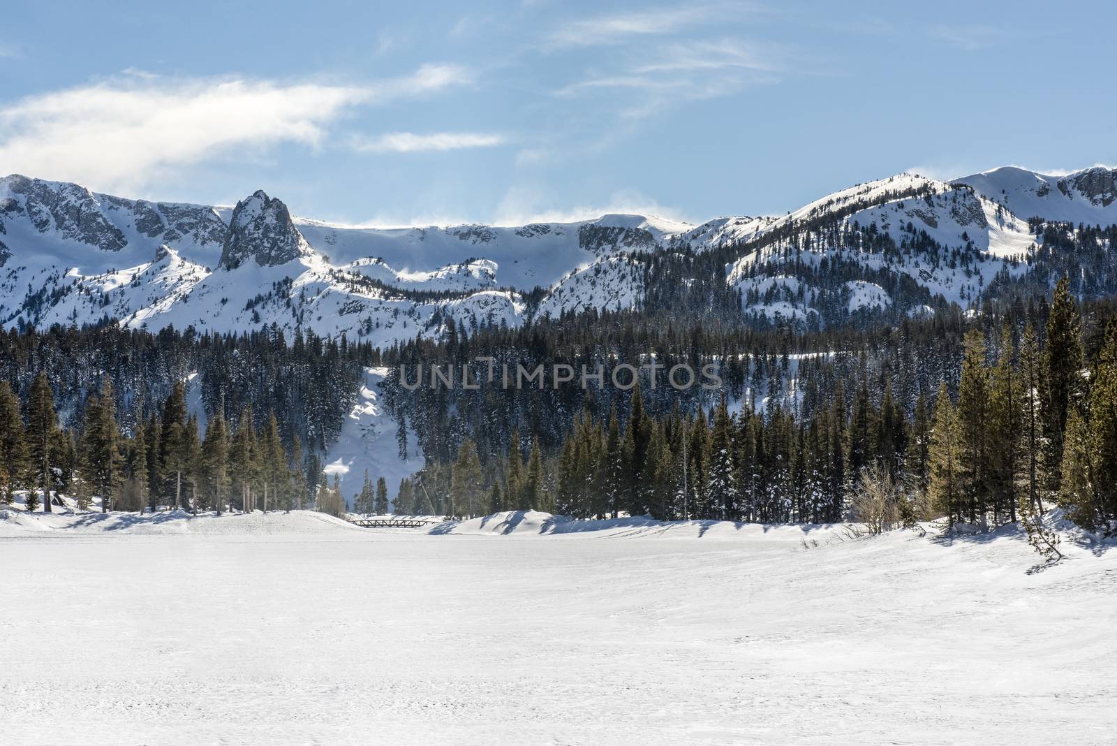 View of Twin Lakes frozen in winter with Mammoth Rock in background in Mammoth Lakes, California