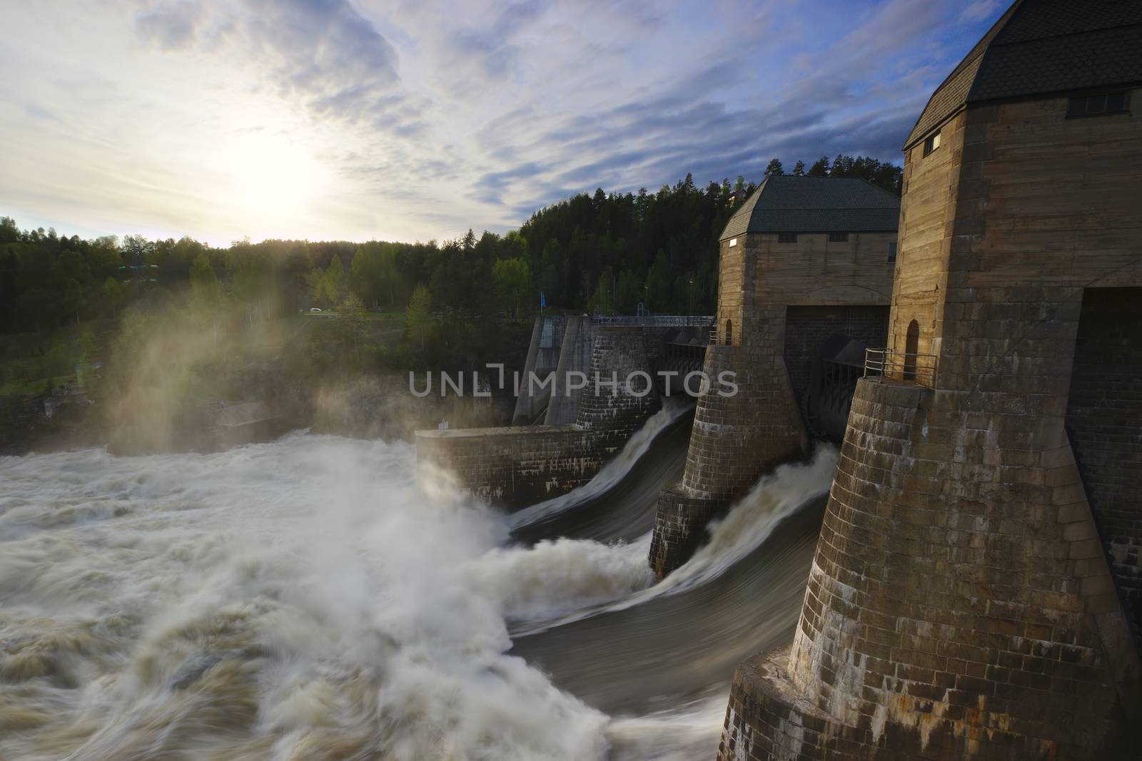 The Solbergfoss Dam in Østfold, Norway. The dam is open, water flowing. Low sun.