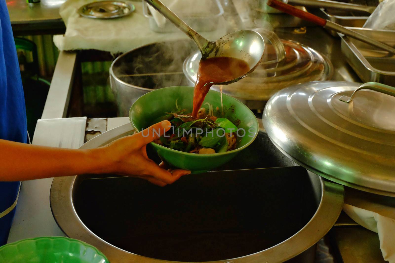 The ladle is drained in a bowl of noodles,Cooking noodle in thailand,the noodles pork and beef.