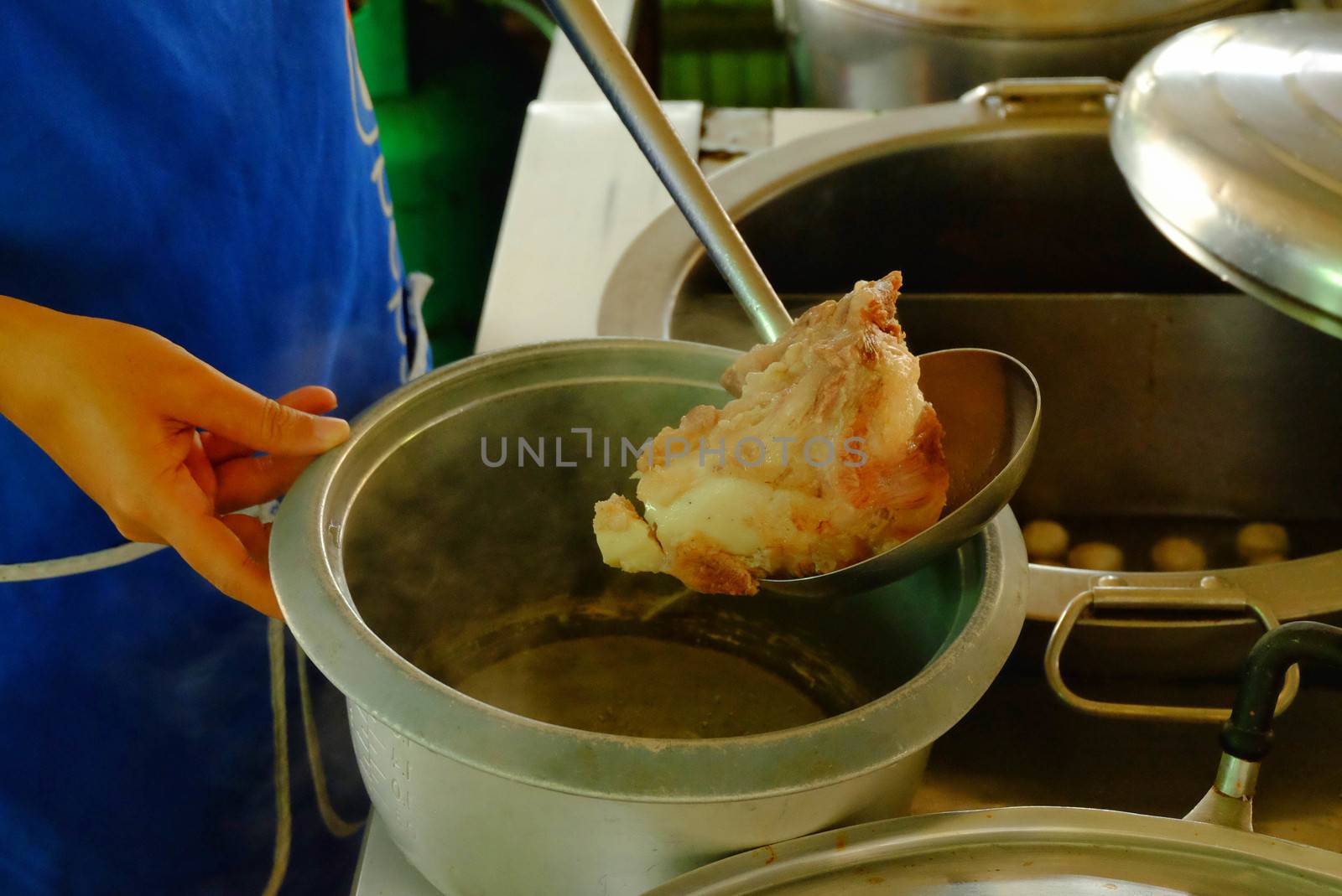 The ladle is drained porksoft in a bowl ,Cooking noodle in thailand,the noodles pork and beef.