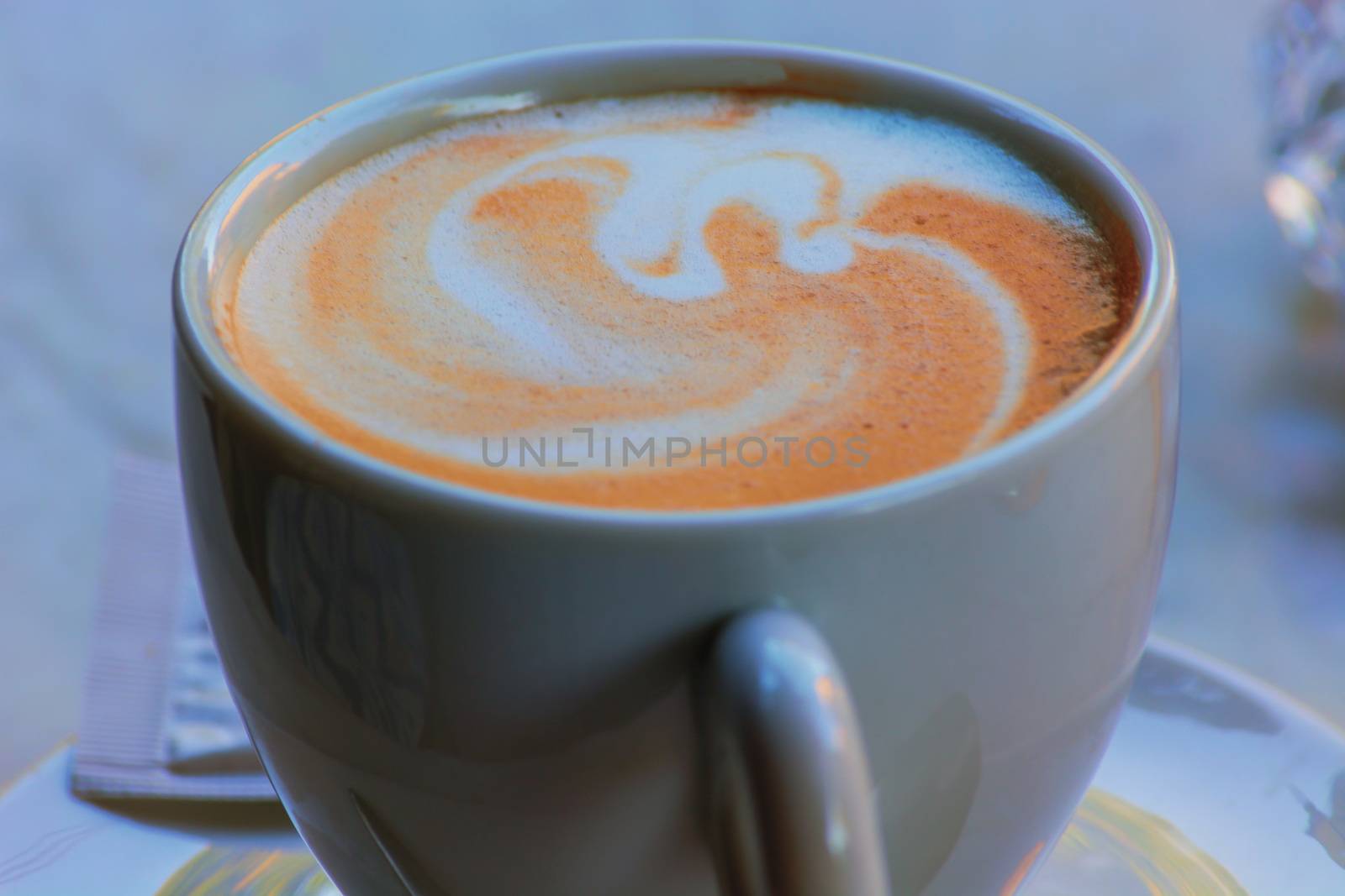 A white cup of coffee latte art before bokeh background