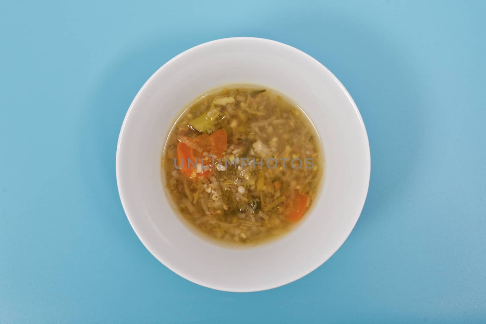 Miso vegetable soup with vegetables on a blue background