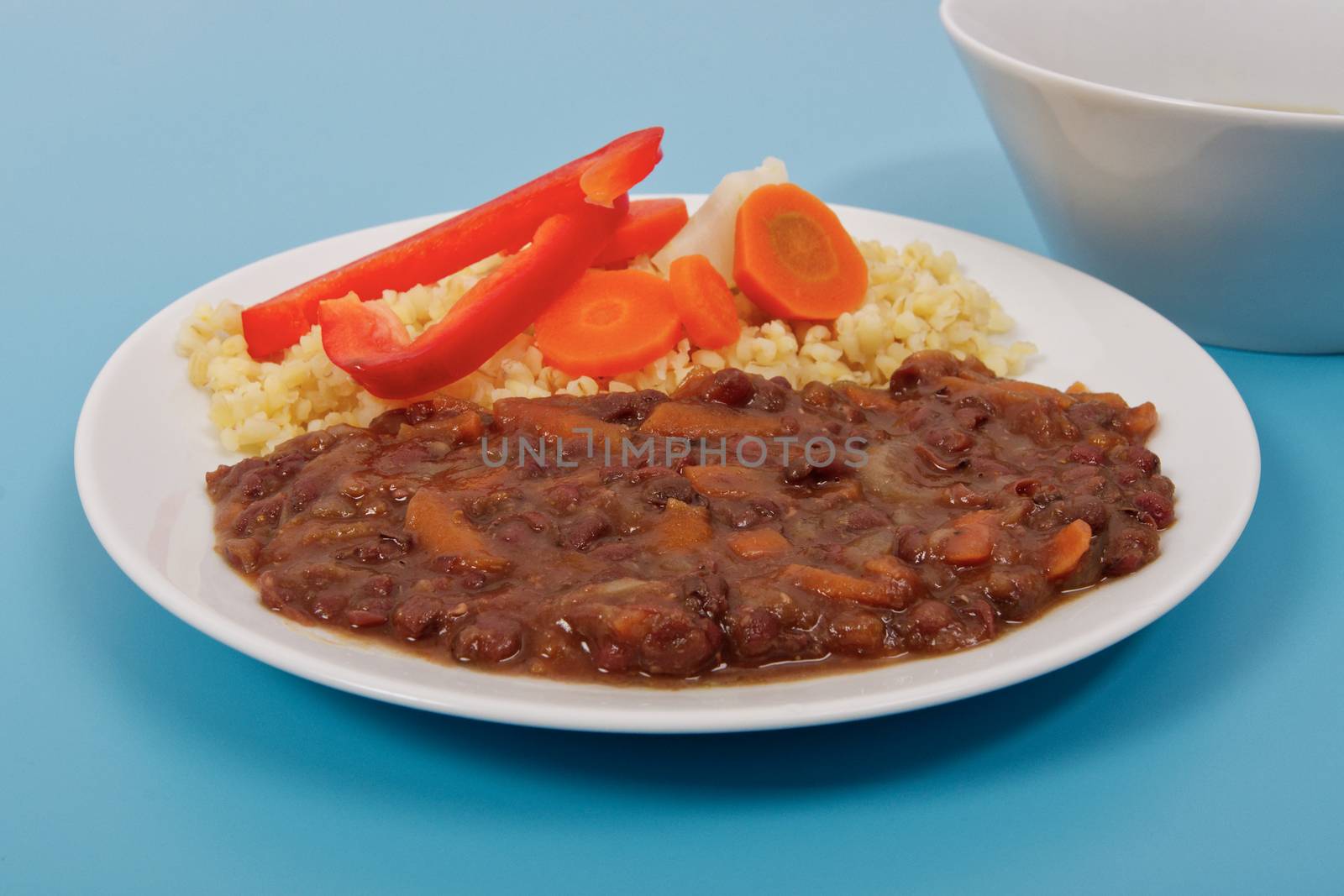 Azuki with vegetables on steam and bulgur on a blue background