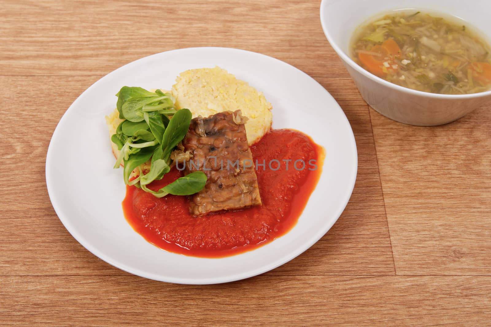 Tempeh with tomato sauce and dumplings on a table by neryx