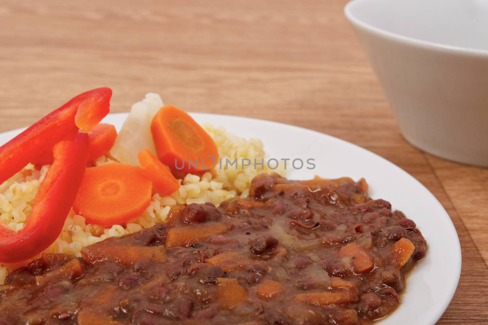 Azuki with vegetables on steam and bulgur on a wooden table