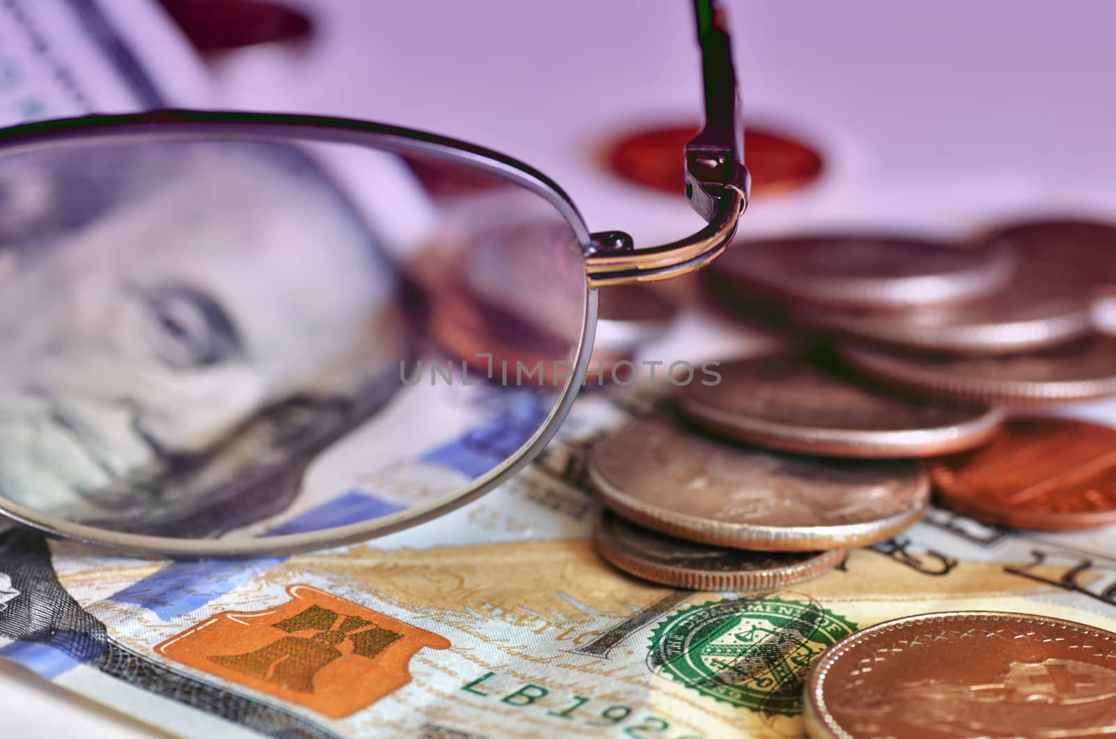 Money and glasses as financial still life image. Few coins and hundred dollars bill. Sharpness on front plan.