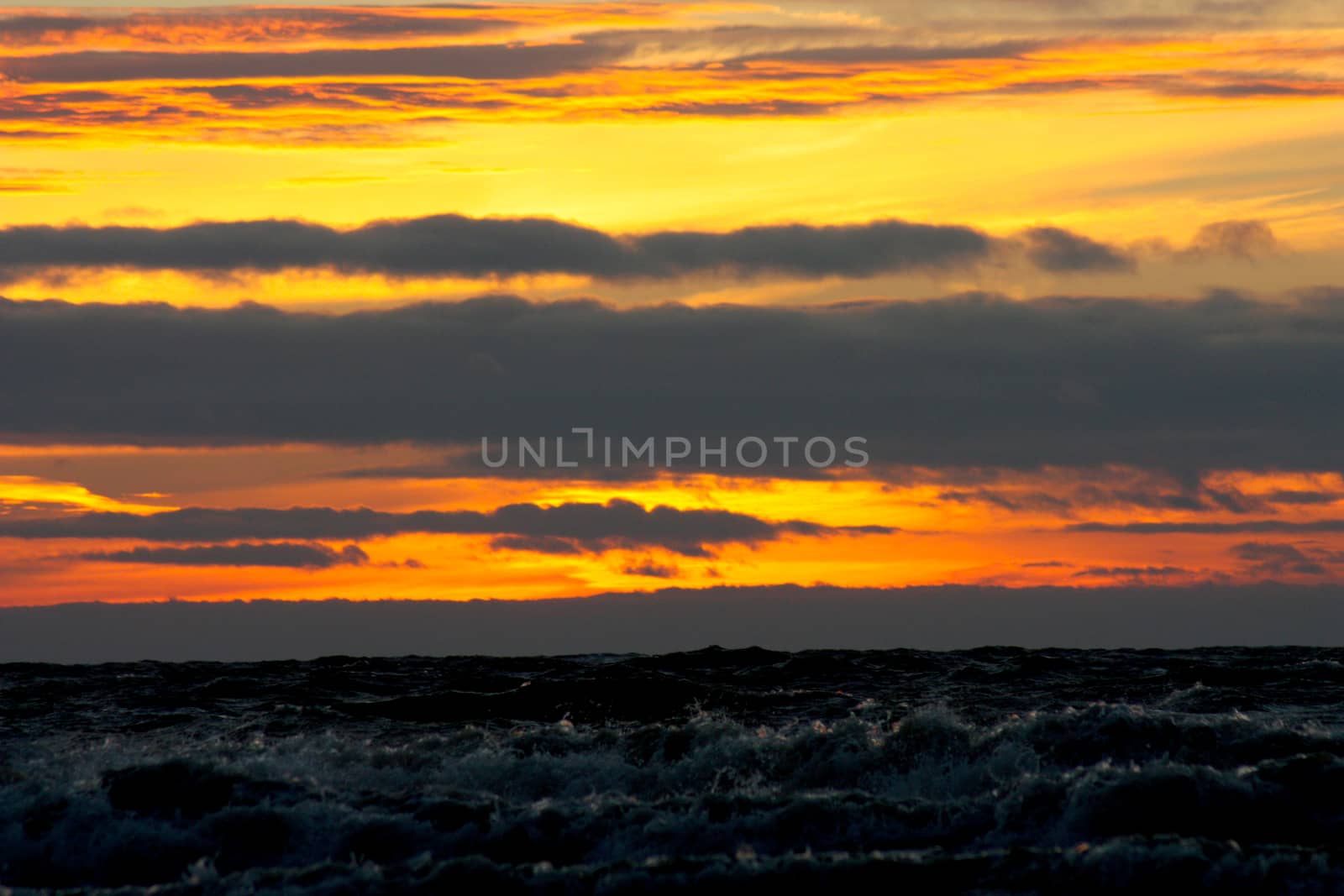 stormy sea against the background of a color sunset. Dramatic sky over storm sea