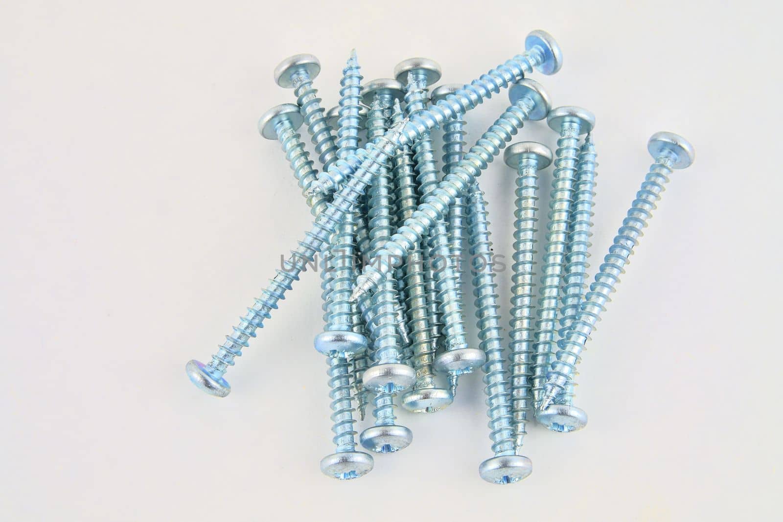 Set of screws for construction on a white background, metal screw, iron screw, chrome screw, screws as a background, wood screw. Close-up by roman_nerud