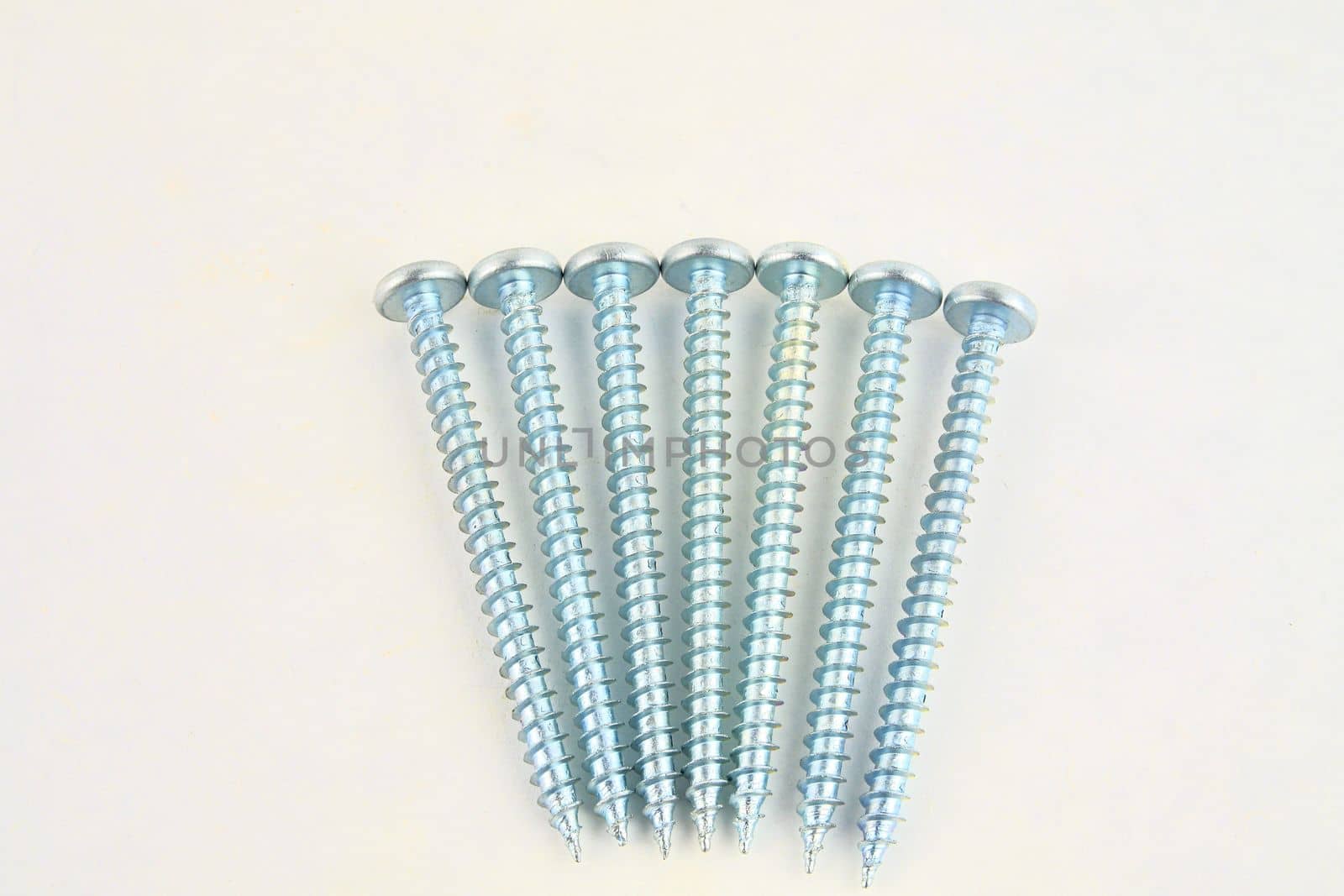 Set of screws for construction on a white background, metal screw, iron screw, chrome screw, screws as a background, wood screw. Close-up.