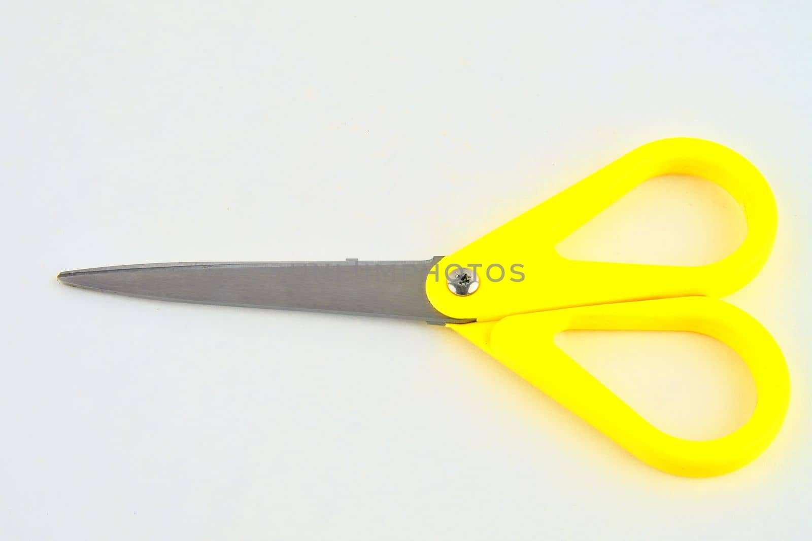 Yellow scissors isolated on a white background. Top view.