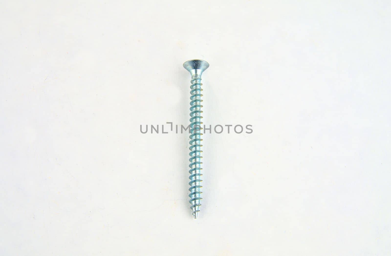 Screw for construction on a white background, metal screw, iron screw, chrome screw, screw as a background, wood screw. Close-up.