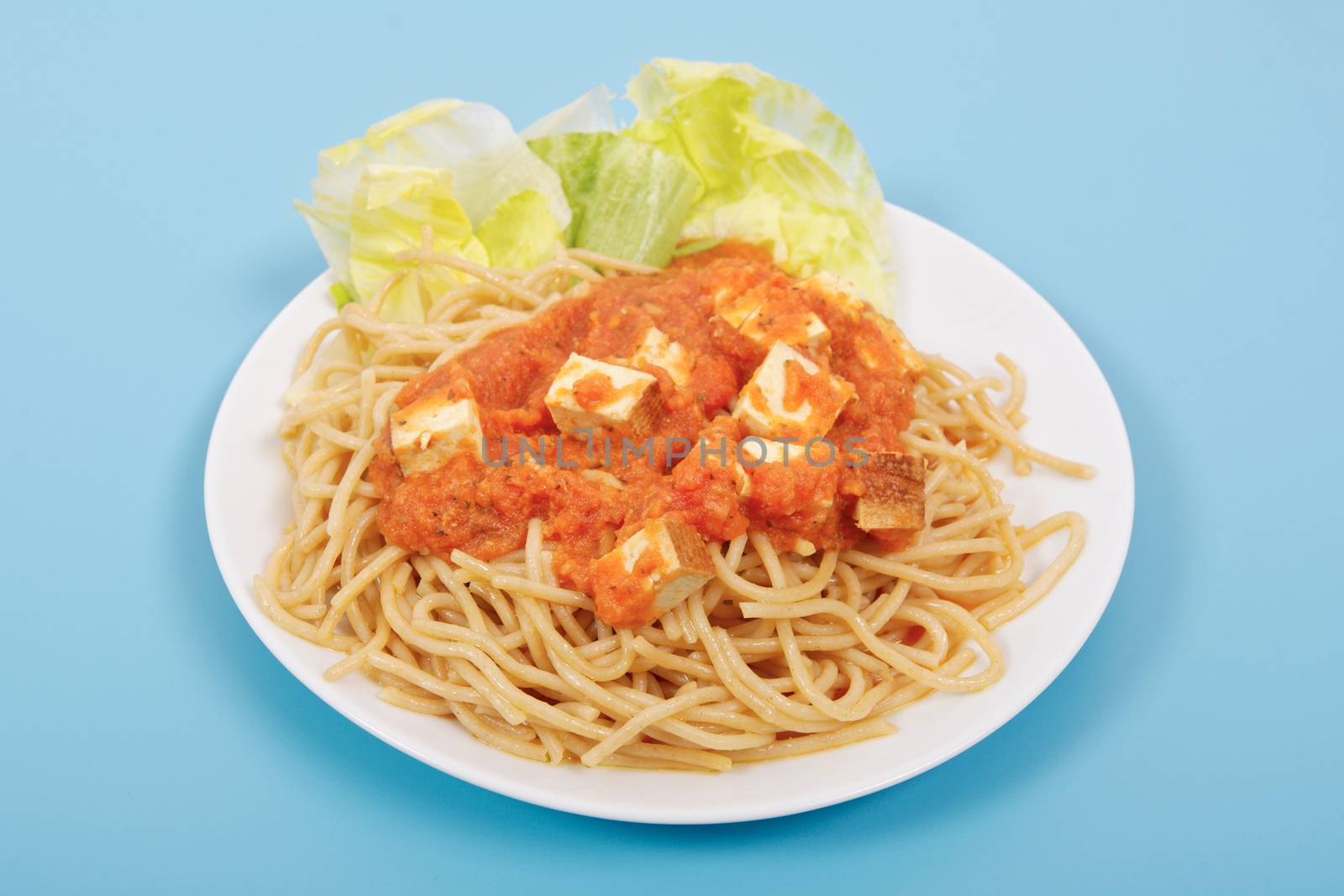 Bolognese spaghetti with tofu on a blue background