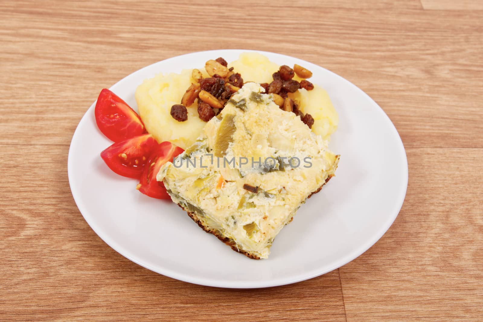 Baked leek with mashed potatoes on a wooden table