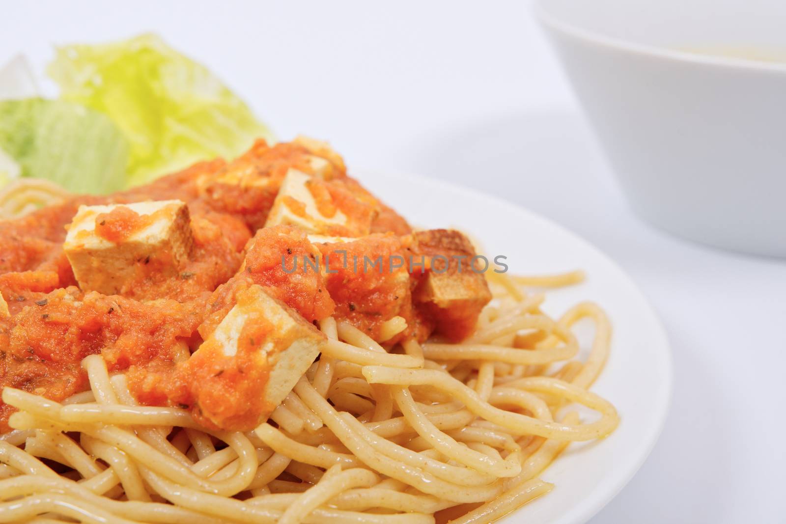 Bolognese spaghetti with tofu on a white background